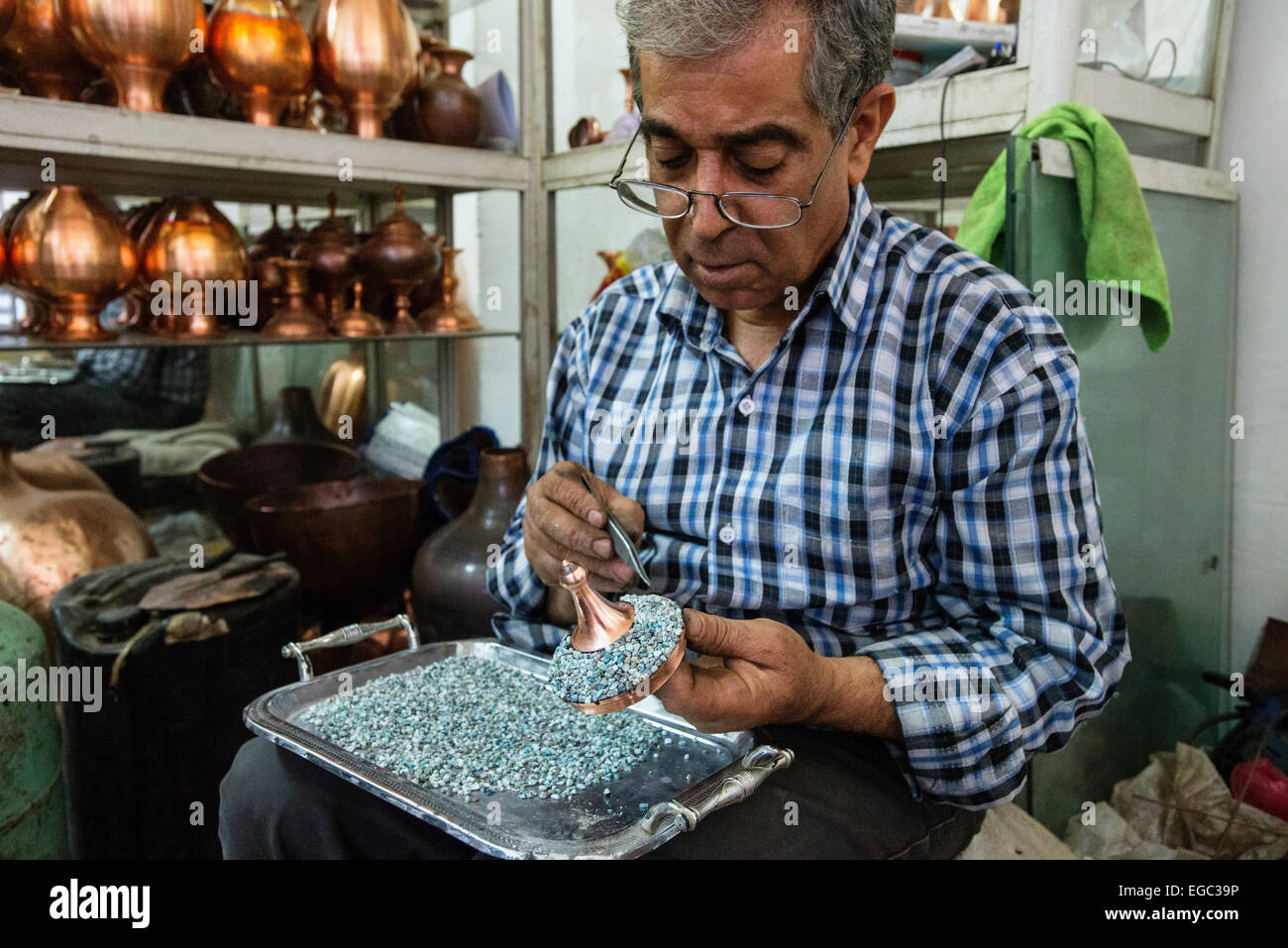 Artist sets mina stones for minakari, unique art of Esfahan, which means decorating metals with colorful and baked coats, Esfahan, Iran Stock Photo