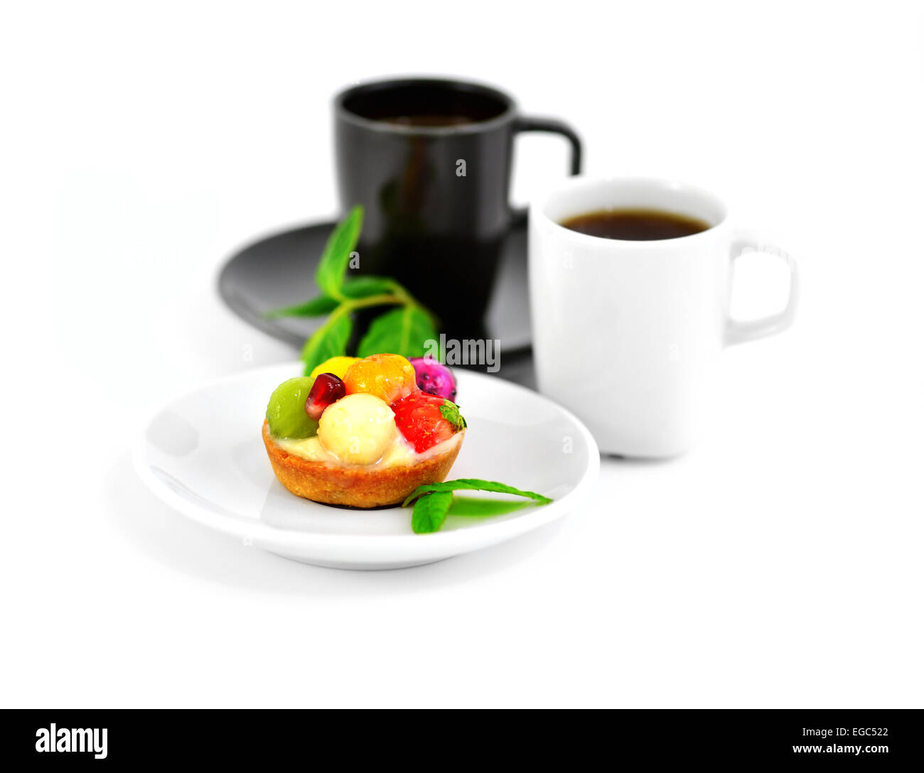 Small fruit cake and two cups of coffee on a blurry background. Stock Photo