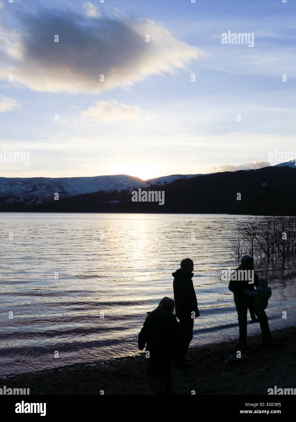 People playing on lakeside in silhouette at sunset Stock Photo - Alamy