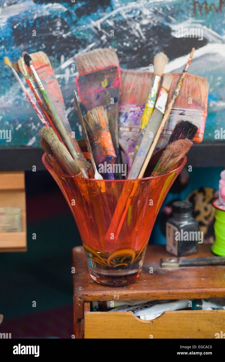 Display Window Of Used Paint Brushes In A Orange Vase On A Chest