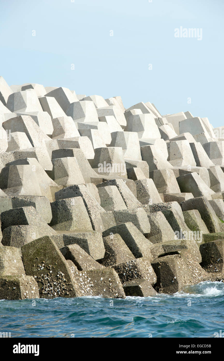 Concrete forms interlocked to make a sea wall breakwater Stock Photo