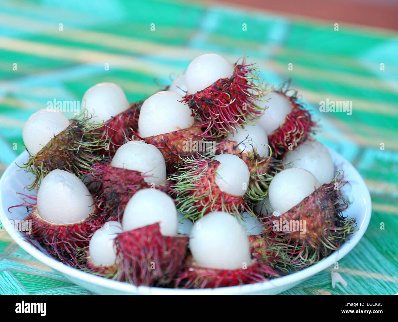 Rambutan fruit is peeled in dish. Stock Photo
