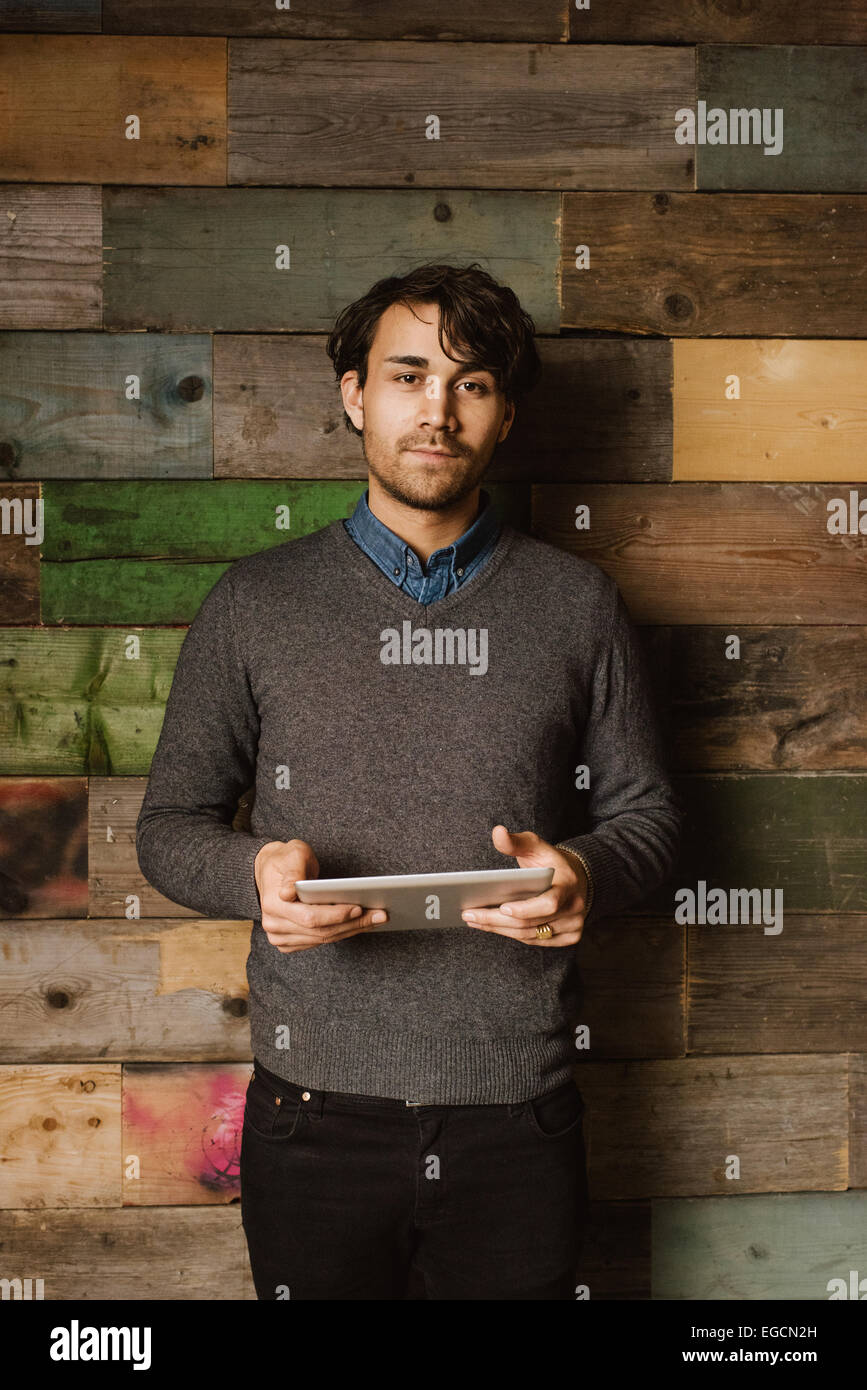 Portrait of a confident young man holding a digital tablet looking at camera. Executive with tablet computer. Stock Photo