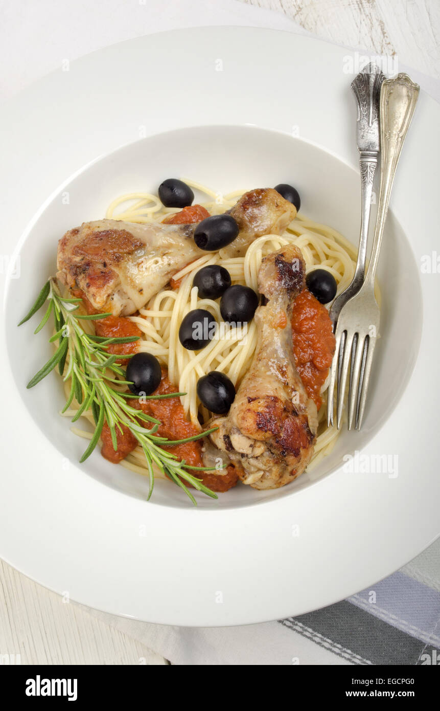 mediterranean chicken drumsticks tomato sauce on spaghetti Stock Photo