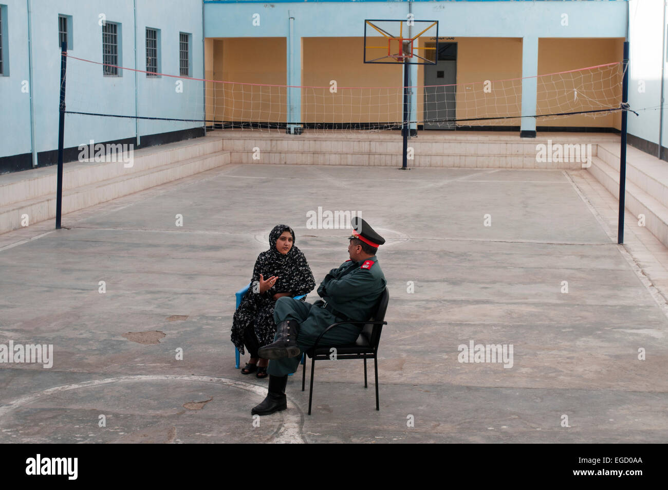 Herat Women's prison. The Prison governor has a private chat with a woman prisoner in the volleyball court. Stock Photo
