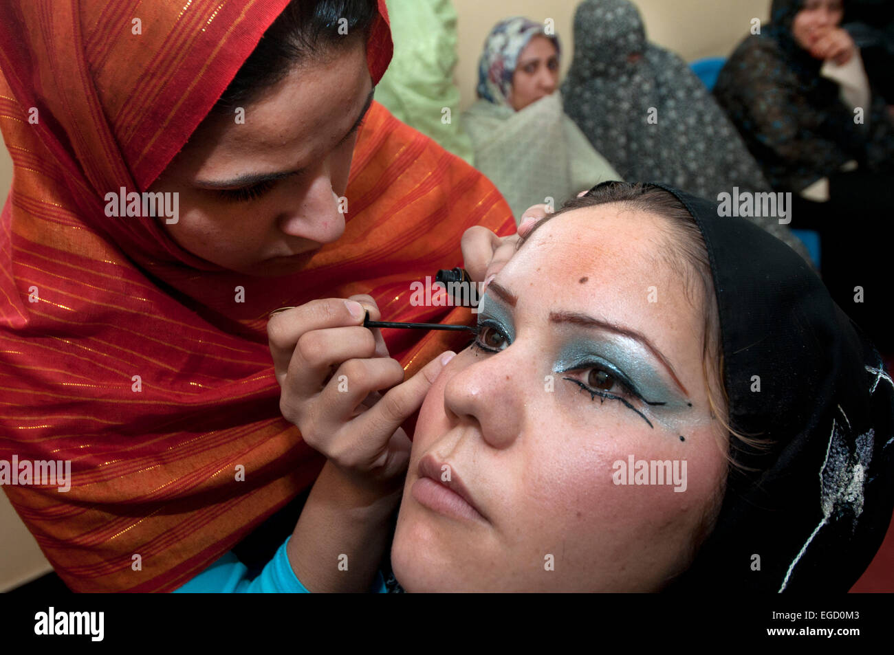 Herat Women's prison - beauty class. One prisoner does the eye make-up of another Stock Photo
