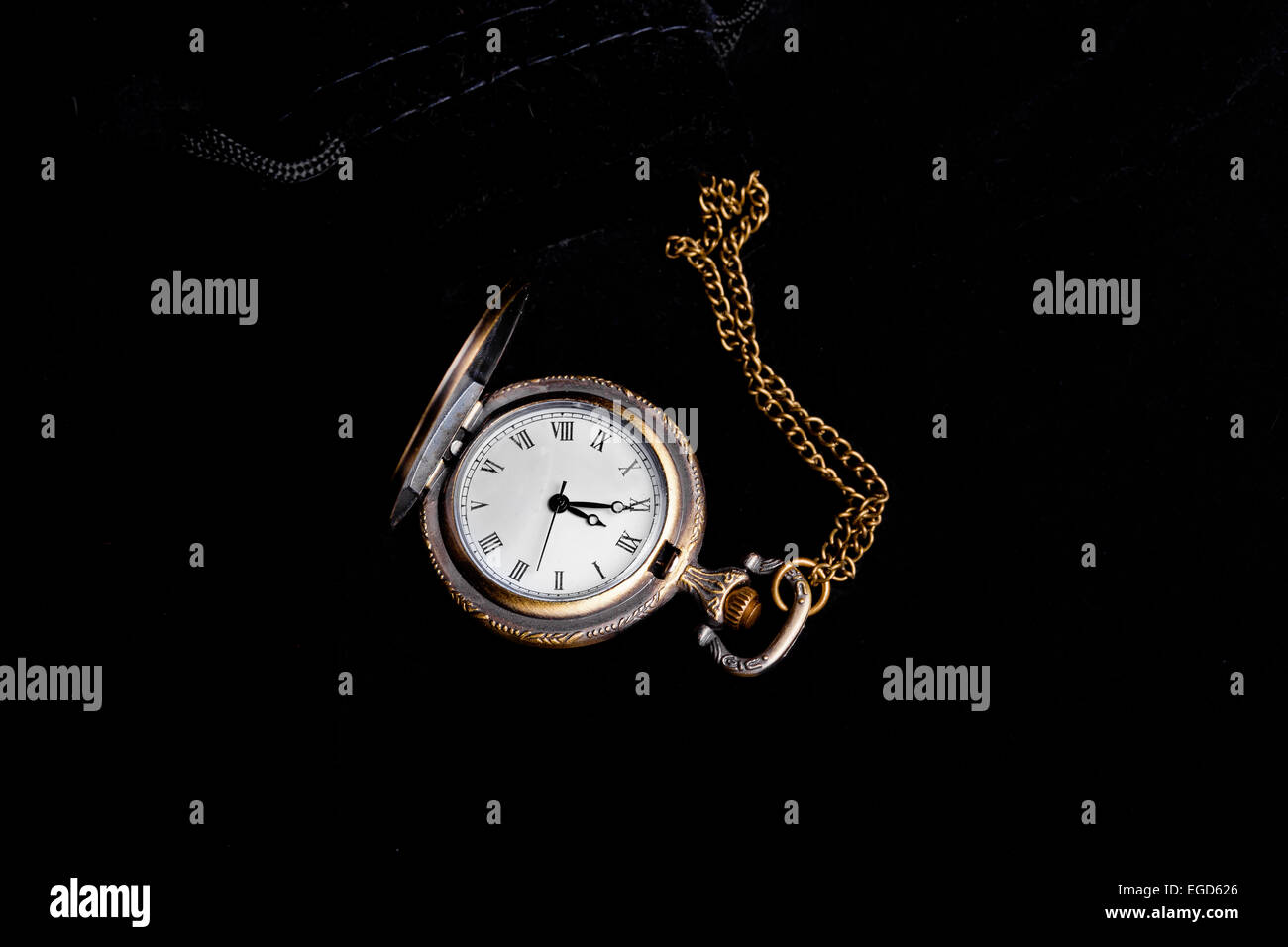 Vintage watch showing five minutes to twelve over black background Stock Photo