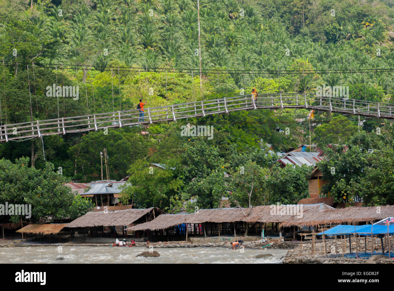 People walking on a hanging bridge, crossing over Bahorok river in Bukit Lawang, Bahorok, Langkat, North Sumatra, Indonesia. Stock Photo
