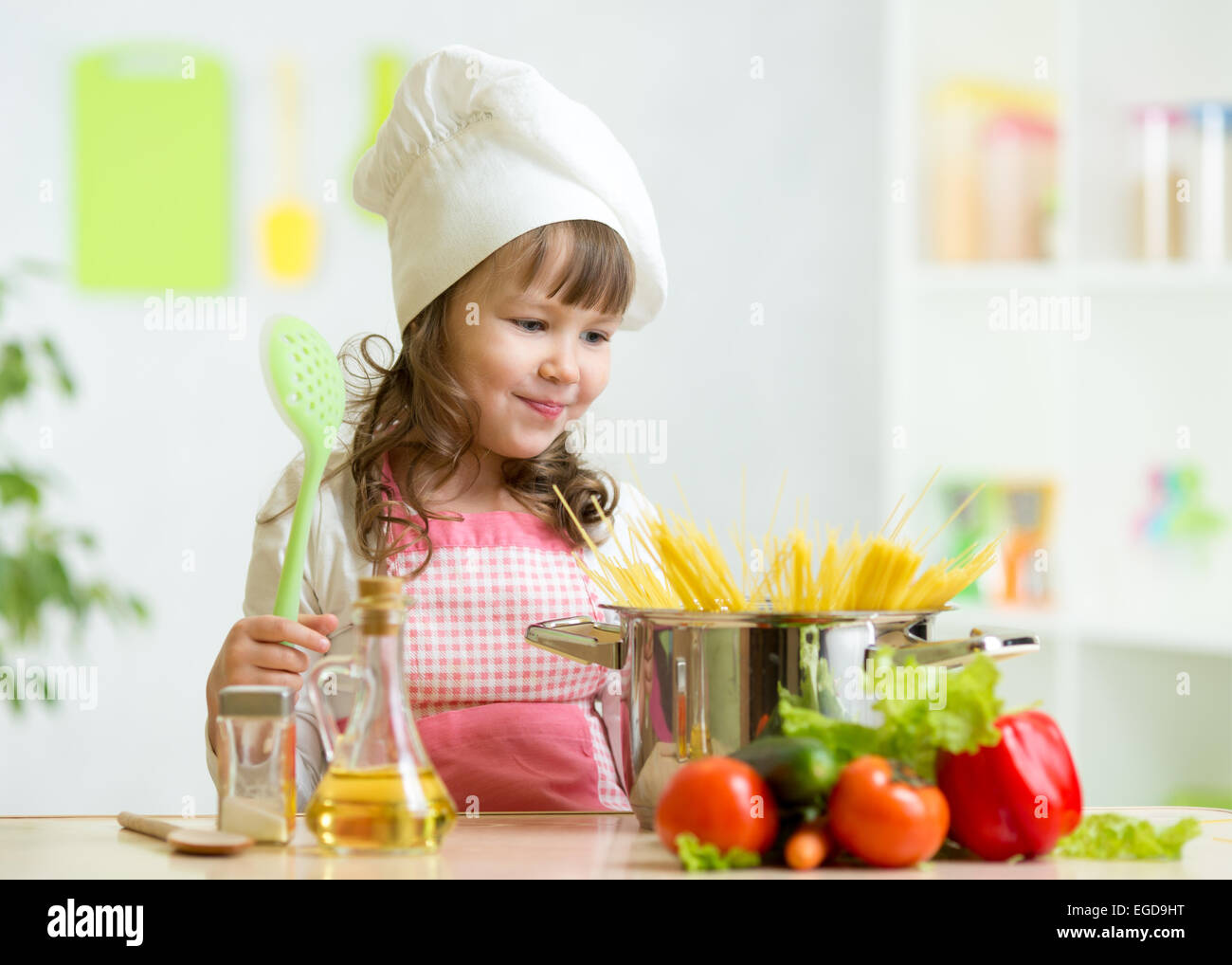 Cook kid makes healthy vegetables meal in the kitchen Stock Photo