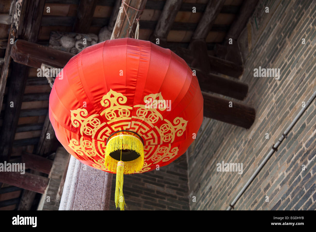 A red traditional Chinese red lantern hang from a wooden roof of a ...