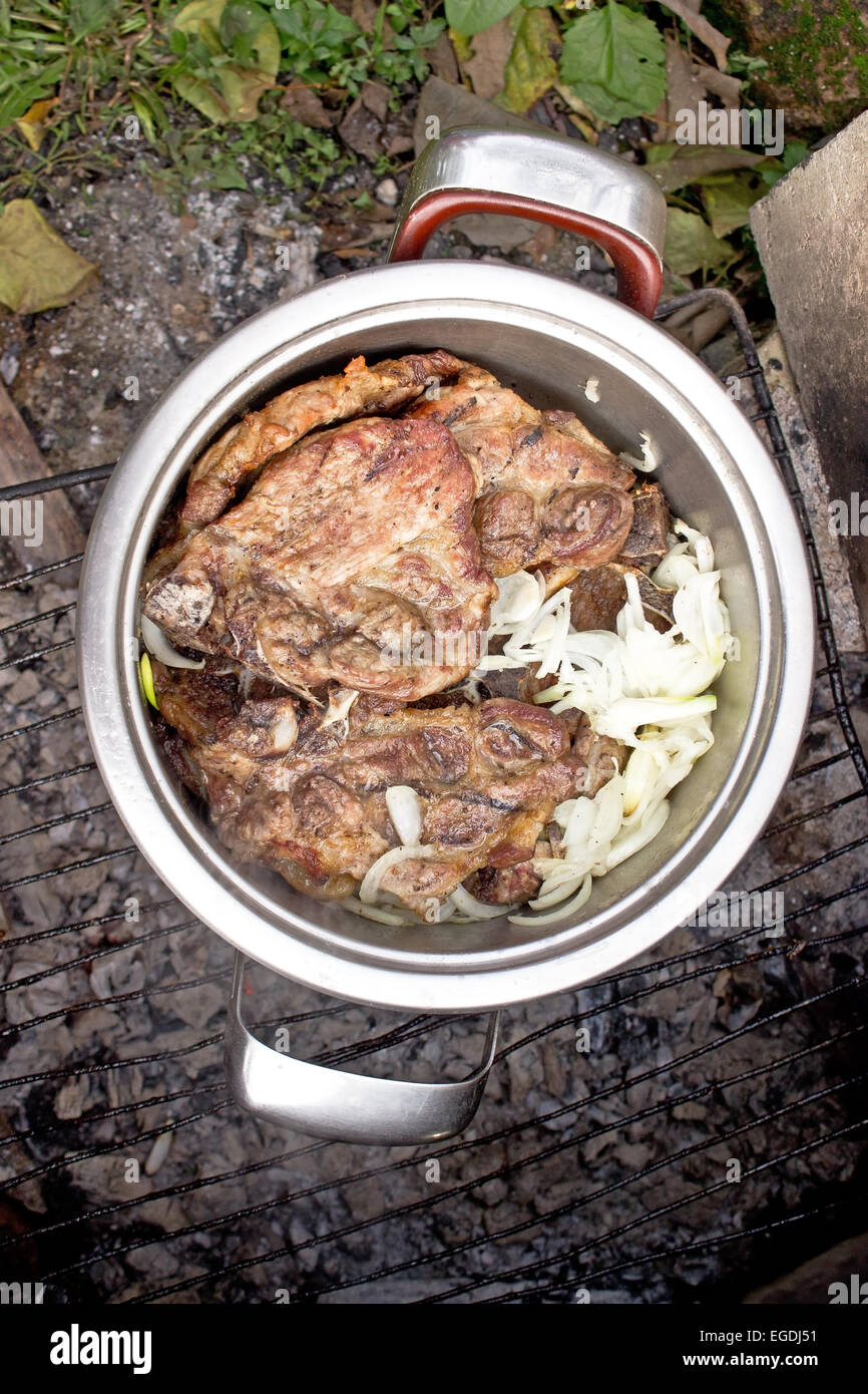 Silver pot full of grilled pork meat barbecue with onion Stock Photo