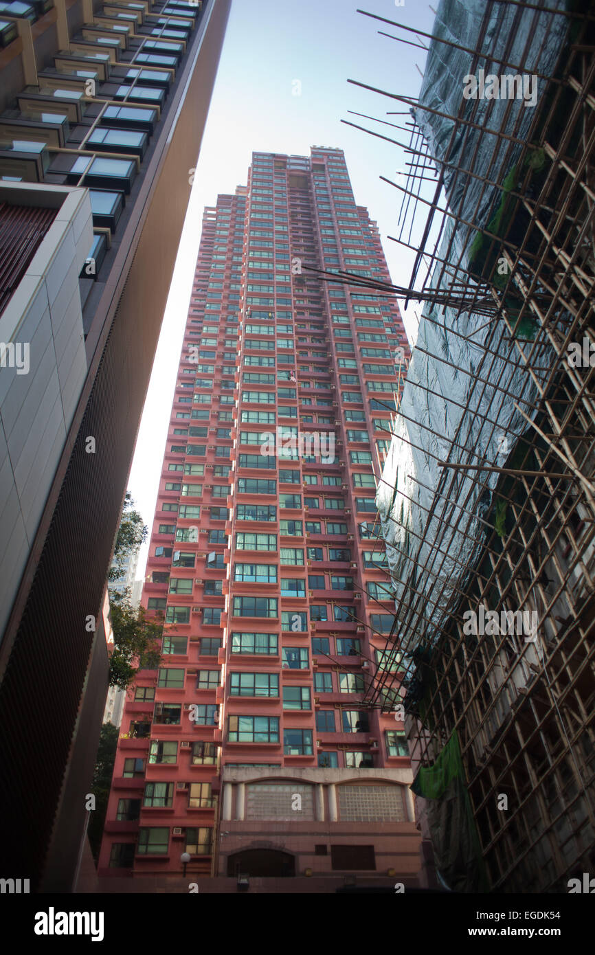 High rises tower high above street level letting very little light in below. Scaffolding made with bamboo covers one building. 7 Stock Photo