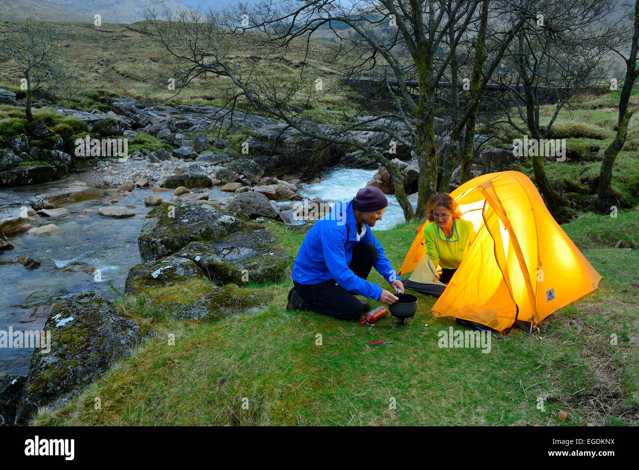 Couple cooking infront of a tent, Glen Etive, Buachaille Etive Mor, Highlands, Scotland, United Kingdom Stock Photo