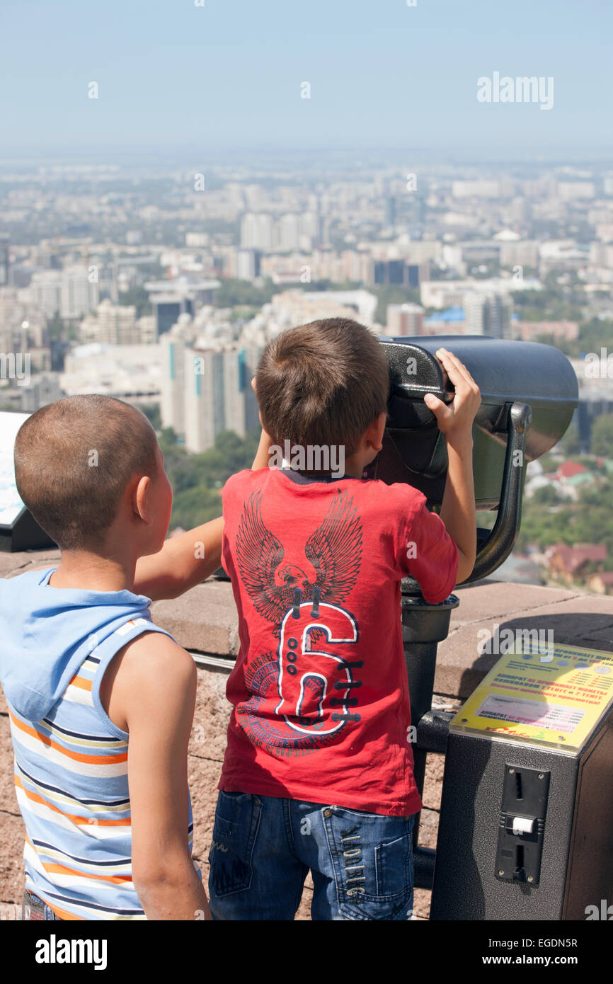 Boys looking at view of Almaty from Kok Tobe mountain, Almaty, Kazakhstan Stock Photo