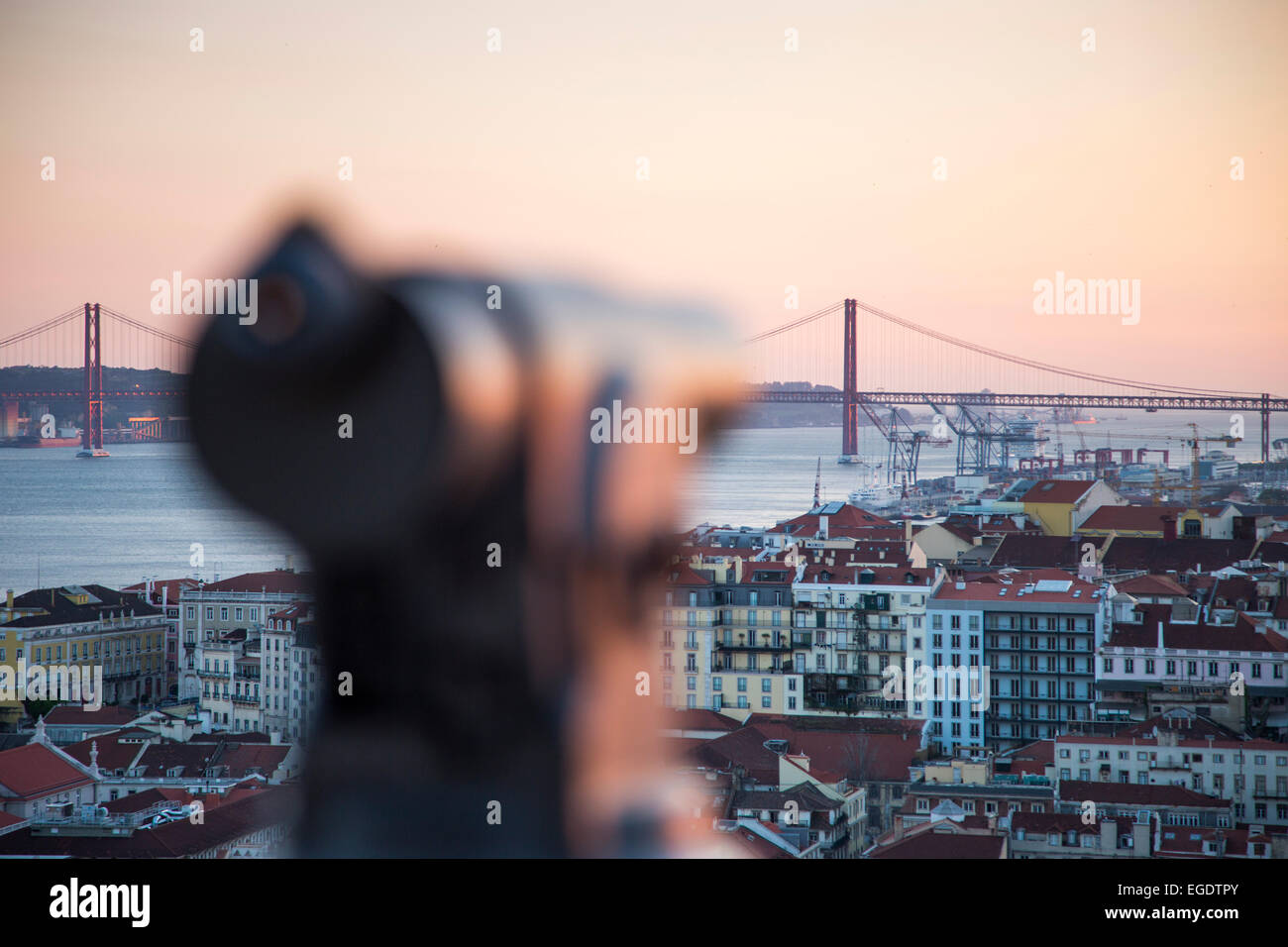 Coin-operated telescope at Castelo de San Jorge, St. George's Castle, in the Alfama district with view over the city and Ponte 25 de Abril bridge over Tagus river at sunset, Lisbon, Lisboa, Portugal Stock Photo