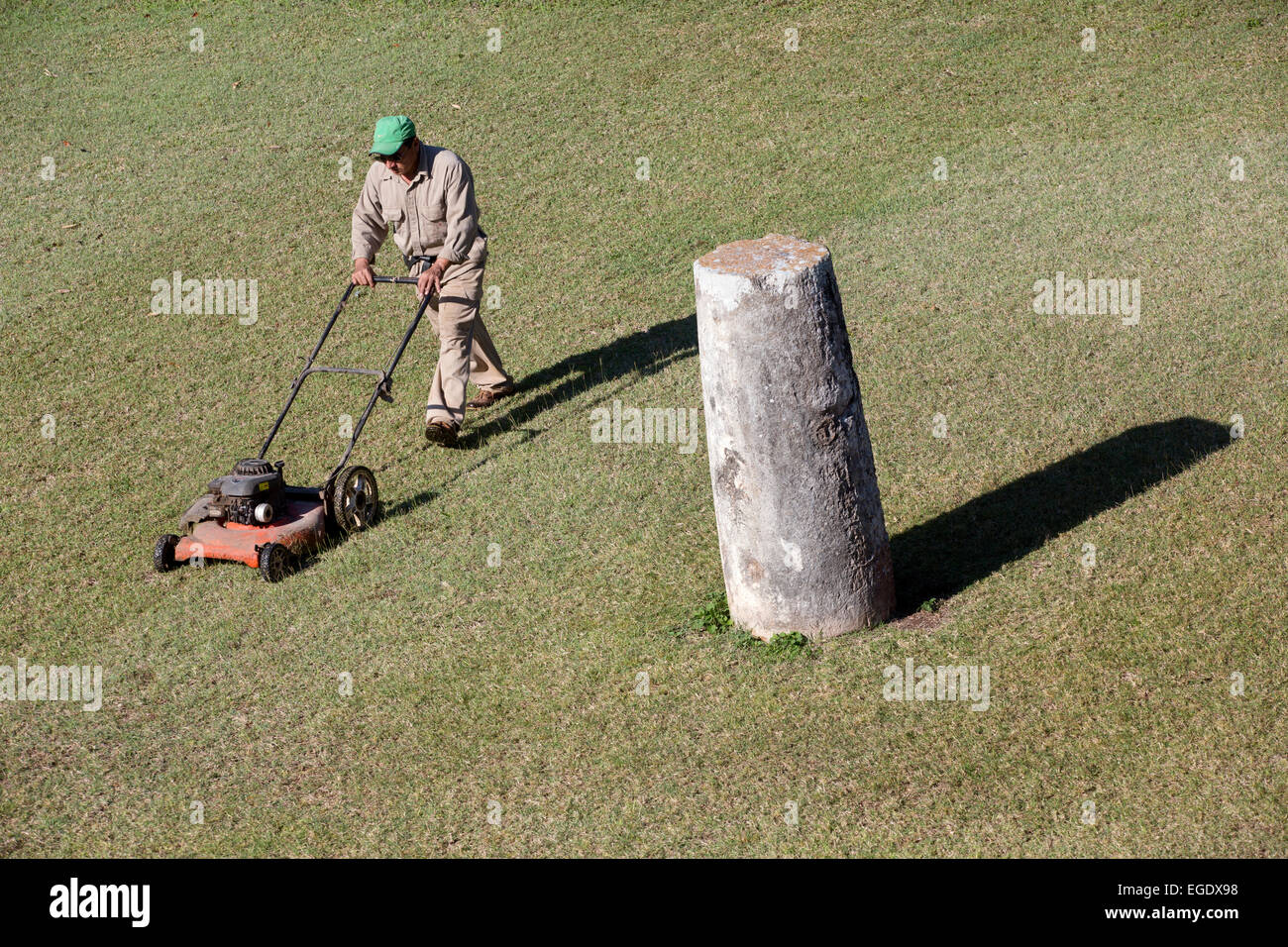 Man mowing grass at Kabah, Yucatan, Mexico Stock Photo