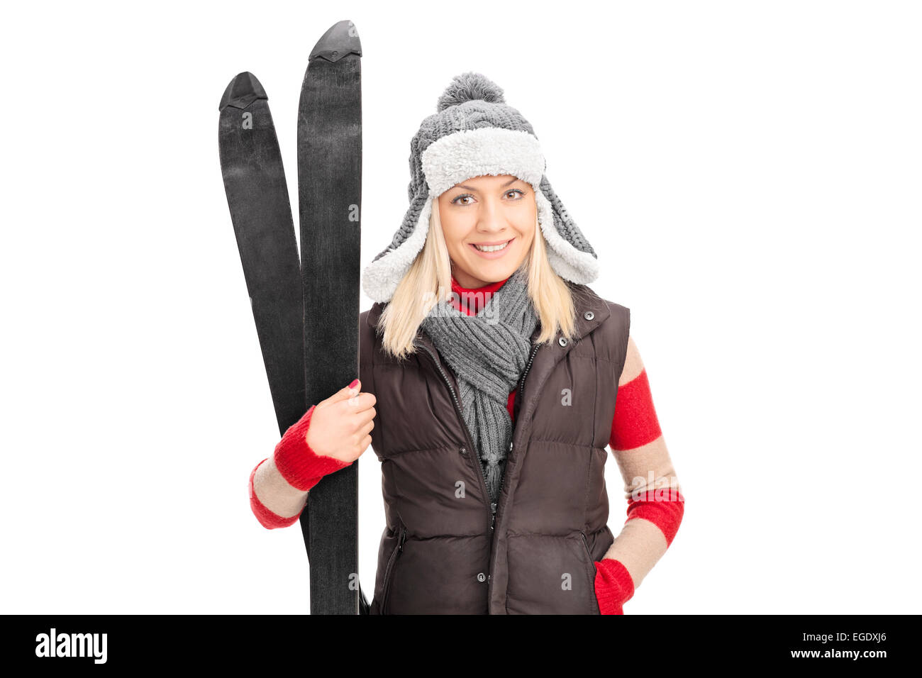 Young girl in winter clothes holding skis isolated on white background Stock Photo