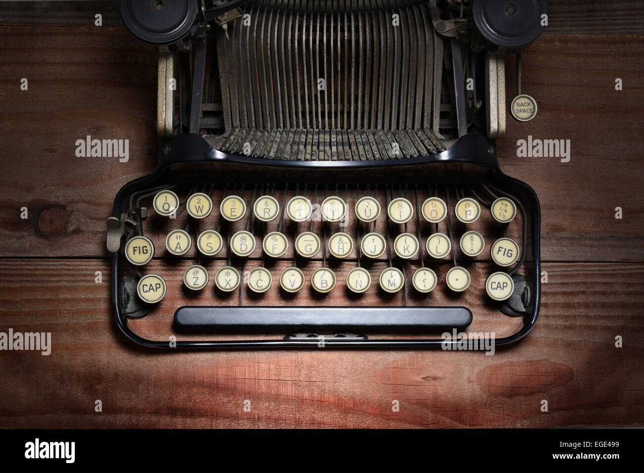 High angle shot of an antique typewriter on a rustic wood table. Stock Photo