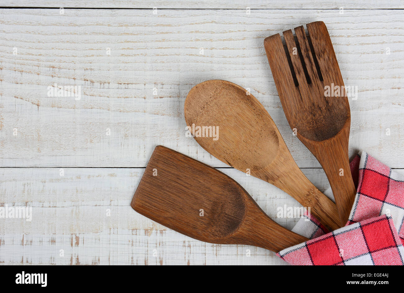 High angle shot of three wooden kitchen utensils in the lower right corner of the frame. The spoon, fork, and spatula are wrappe Stock Photo