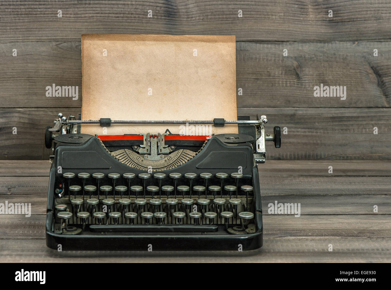 antique typewriter with grungy textured paper page on wooden table. vintage style still life Stock Photo