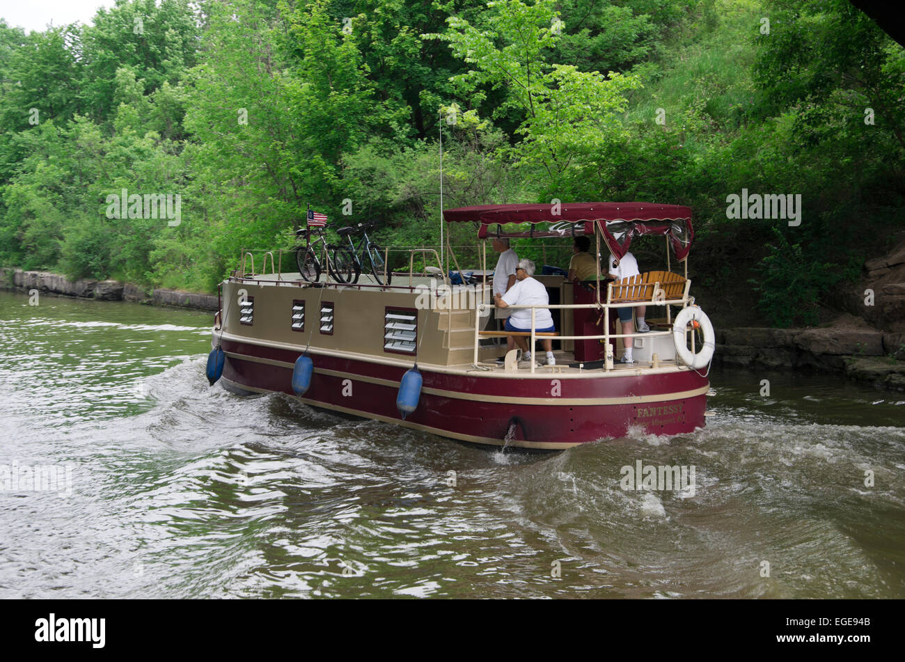 Charter boat cruises on Erie Canal. Passengers on stern look ahead
