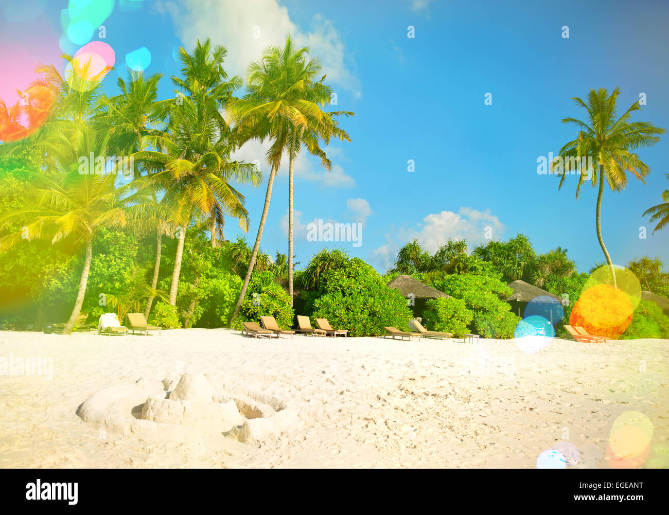 Tropical island sand beach with palm trees and cloudy blue sky. Retro ...