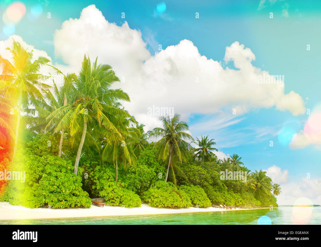 Tropical sand beach with palm trees and sunny blue sky. Vintage style ...