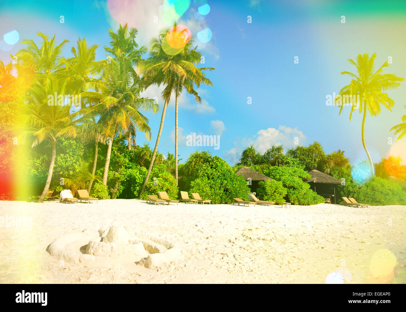 Tropical sand beach with palm trees and sunny blue sky. Vintage style ...