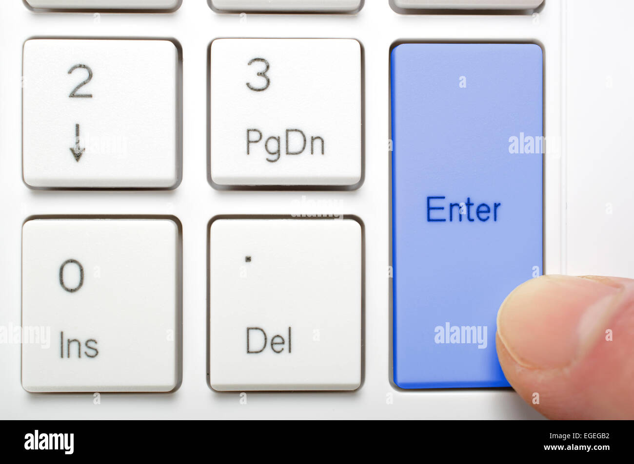 Pressing blue enter key on keyboard Stock Photo