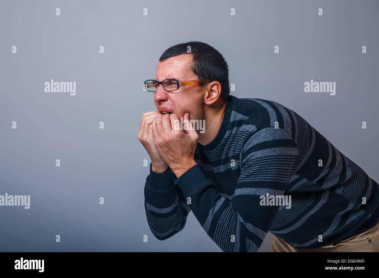 male of European appearance dark hair stuck his hands in his mou Stock Photo