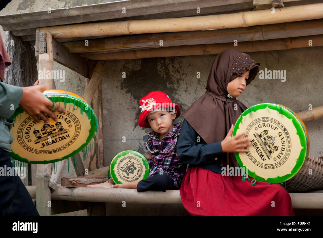 A group of rural children playing rebana, as they are training themselves for an Islamic music performance in Buni, Bekasi , West Java, Indonesia. Stock Photo