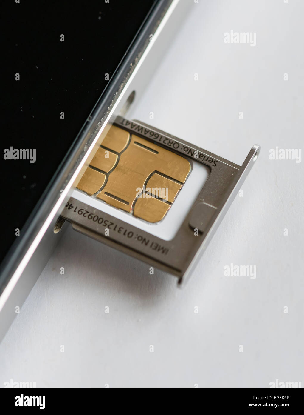 A micro SIM-card is inserted into an Apple iphone 4 smartphone. Stock Photo