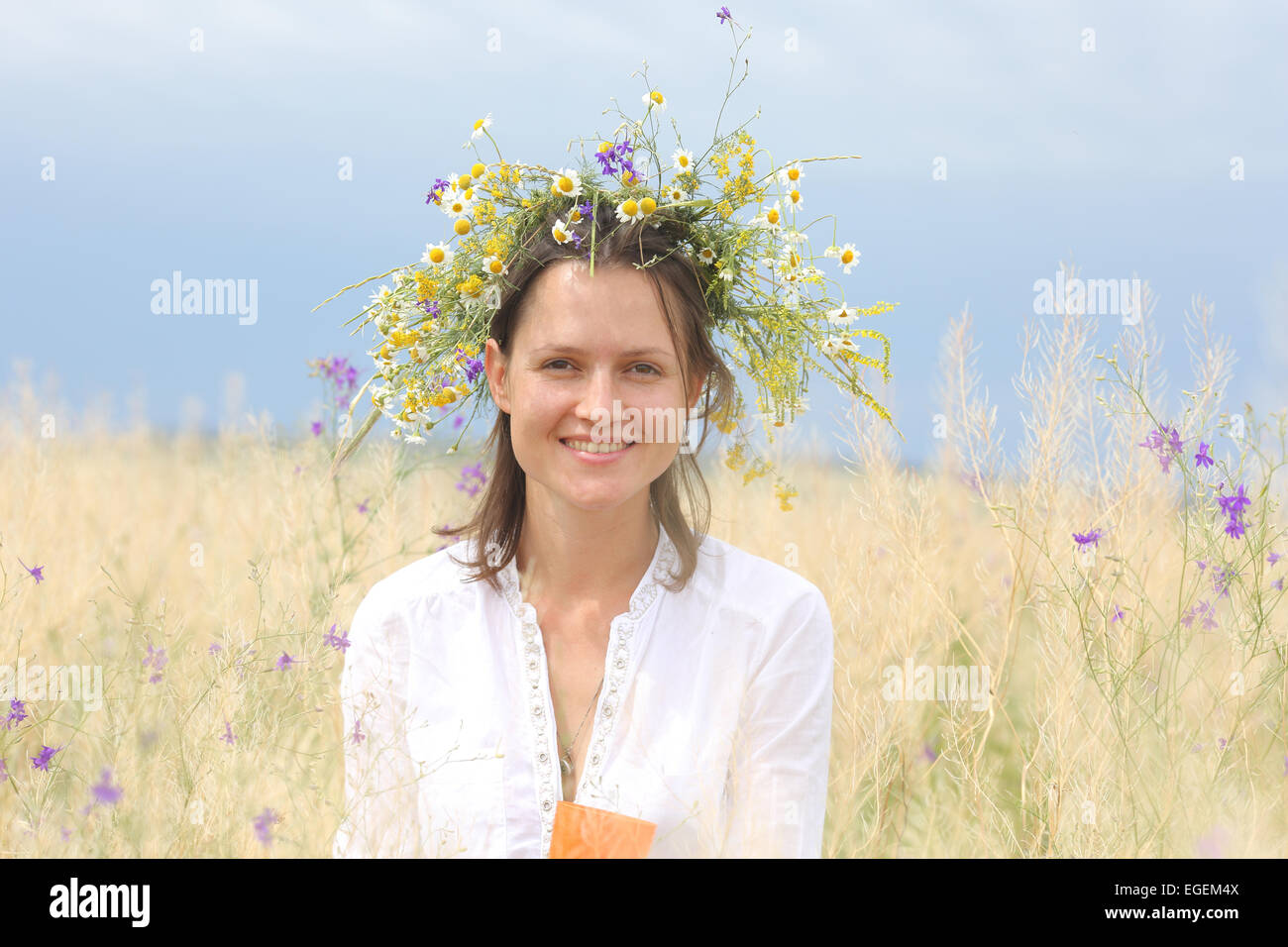 in a lush field girl with a wreath of flowers on her head Stock Photo ...