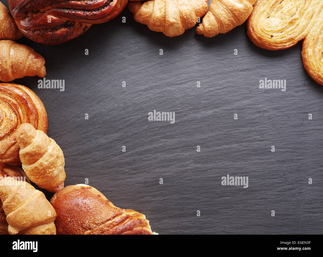 Bakery products arranged as frame on gray board. Stock Photo