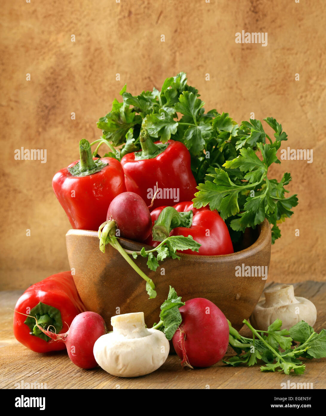 Mix vegetables (tomatoes, cucumbers, mushrooms, herbs) on a wooden table Stock Photo