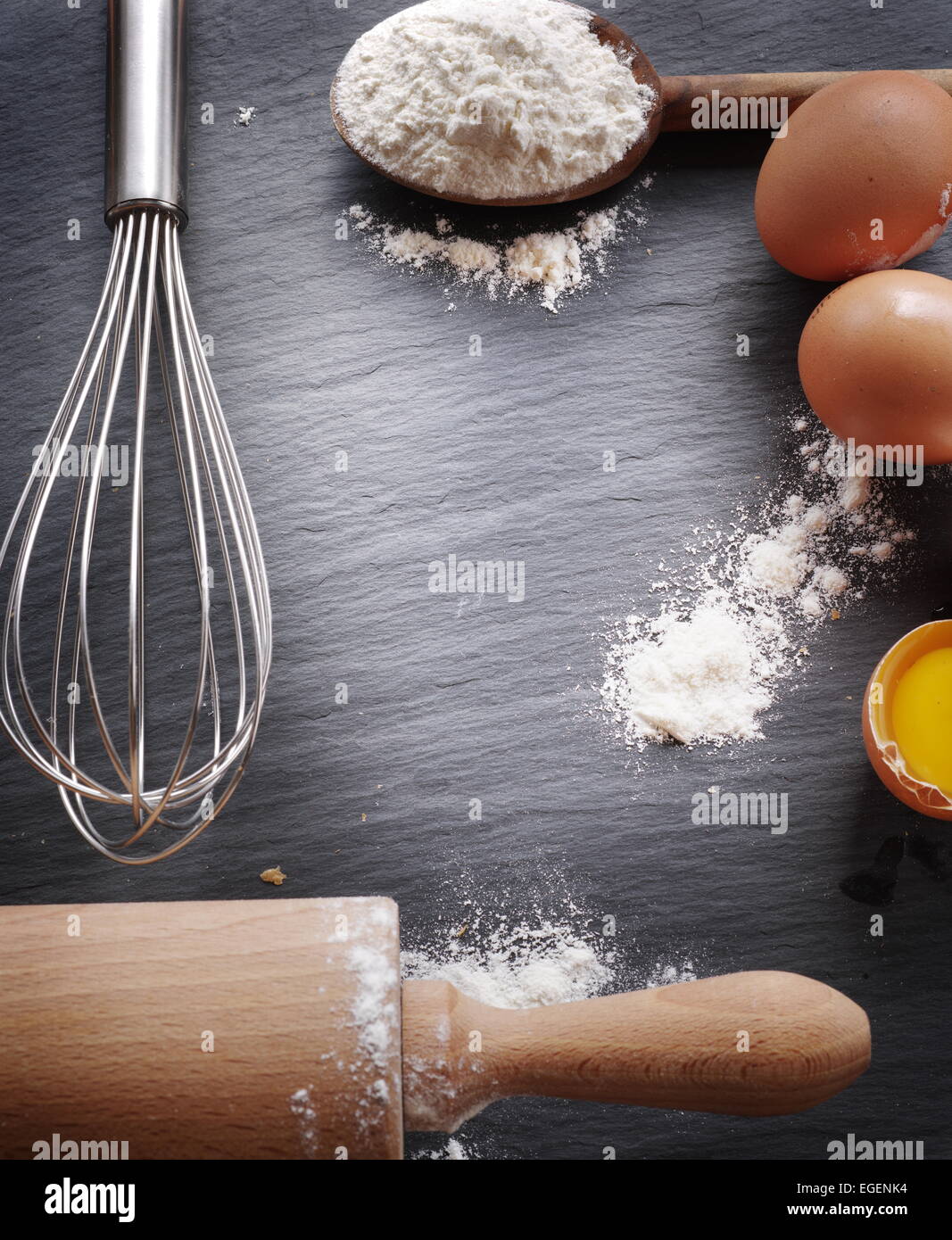 Dough preparation. Baking ingredients: egg and flour on black board. Stock Photo