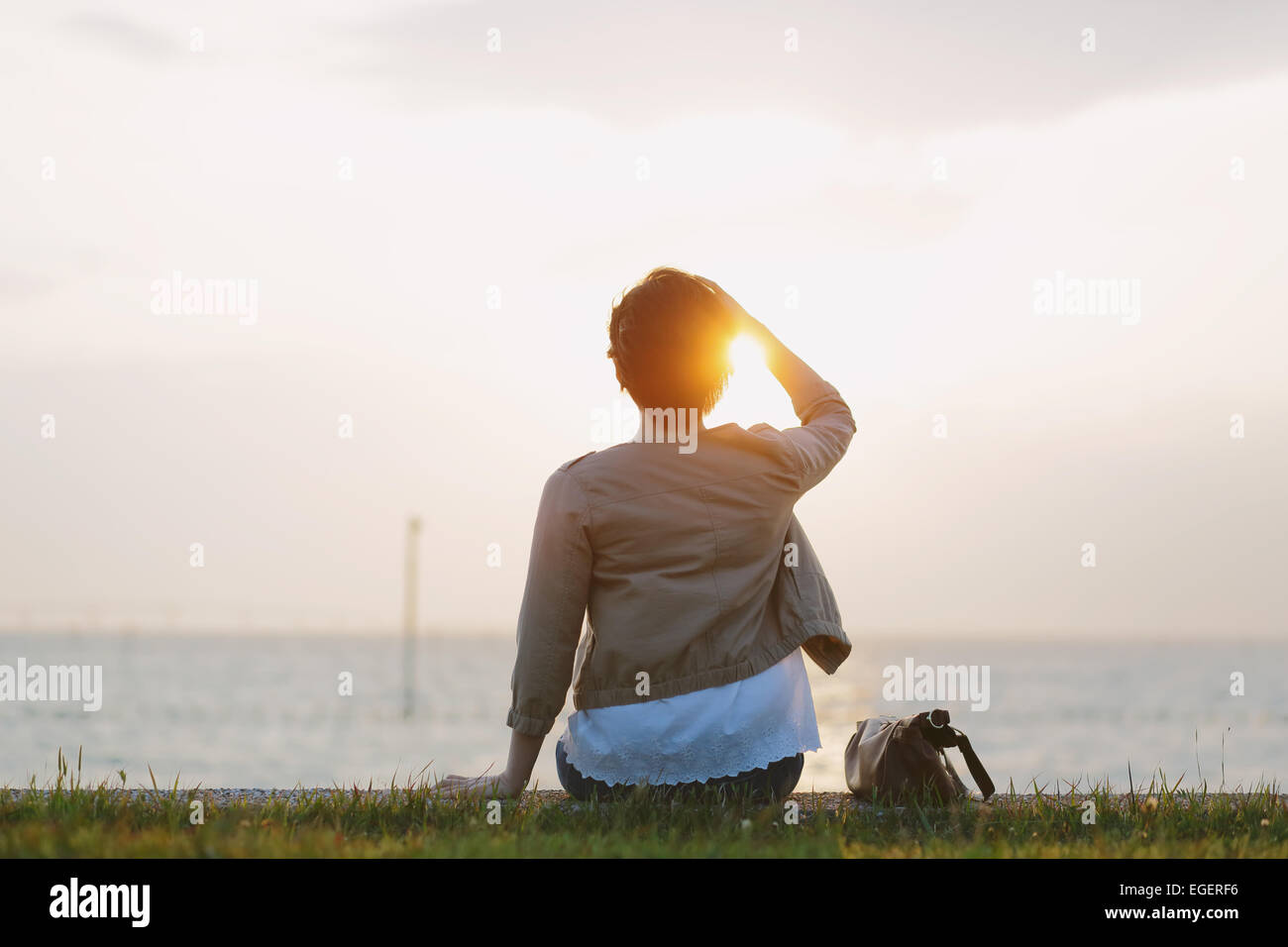 Young Japanese woman sitting by the sea Stock Photo - Alamy
