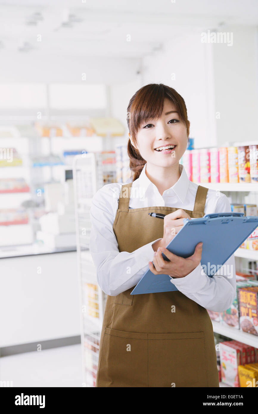 Young Japanese woman working at convenience store Stock Photo - Alamy