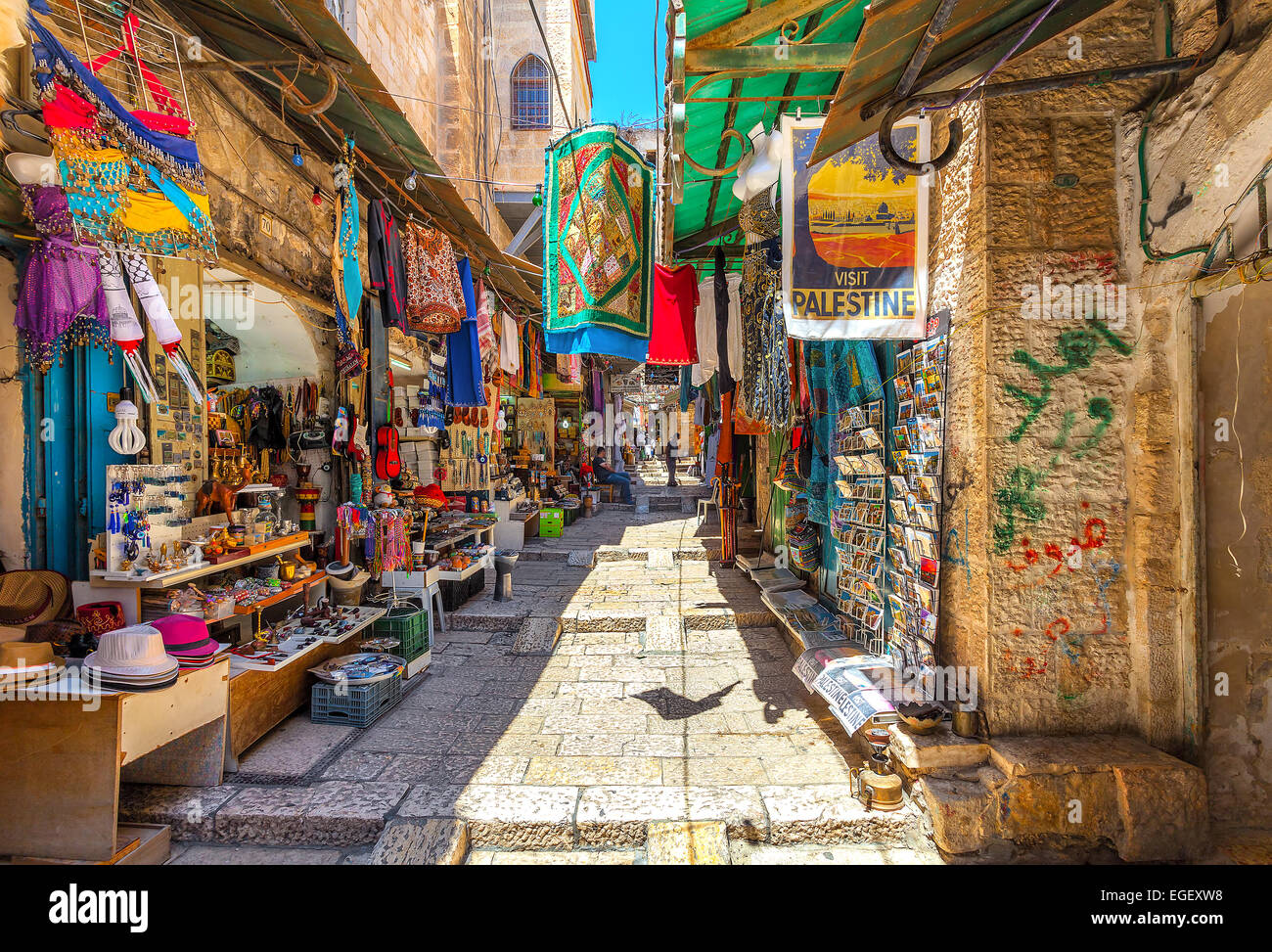 Narrow stone street among stalls with traditional souvenirs and goods at bazaar in Jerusalem. Stock Photo