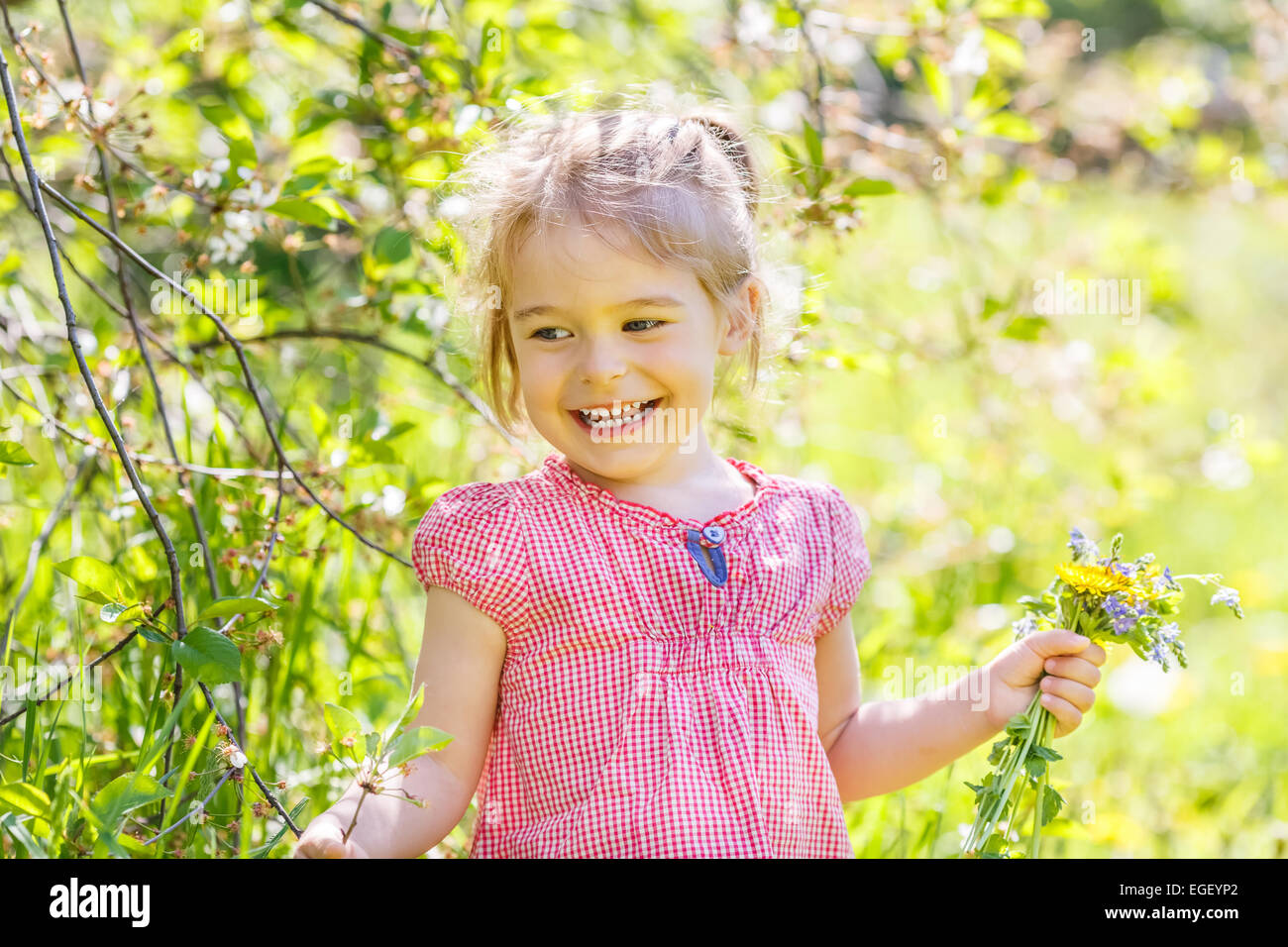 Happy little girl in spring sunny park Stock Photo - Alamy