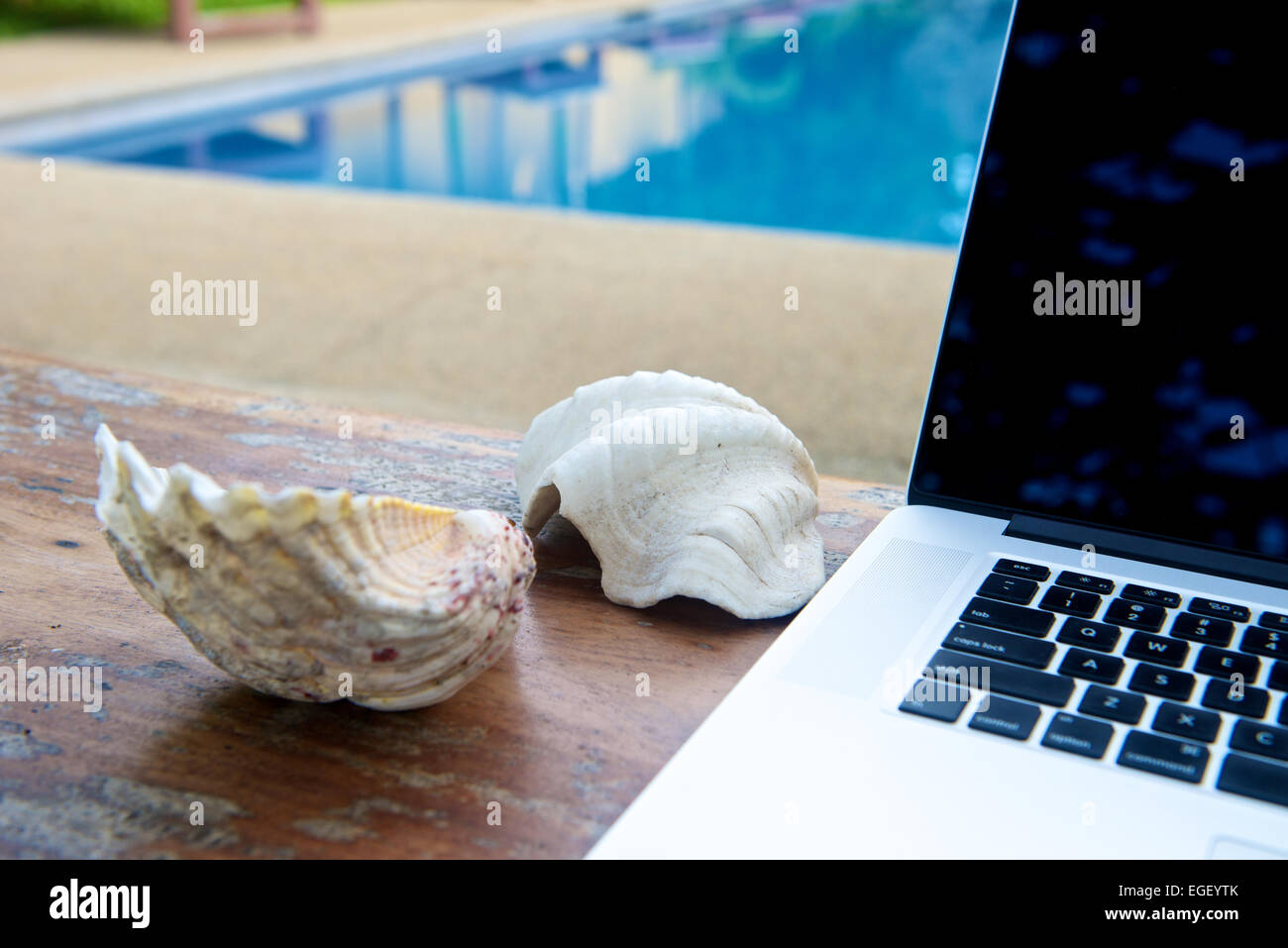 Laptop by the pool, working on vacation with mobility concept Stock Photo