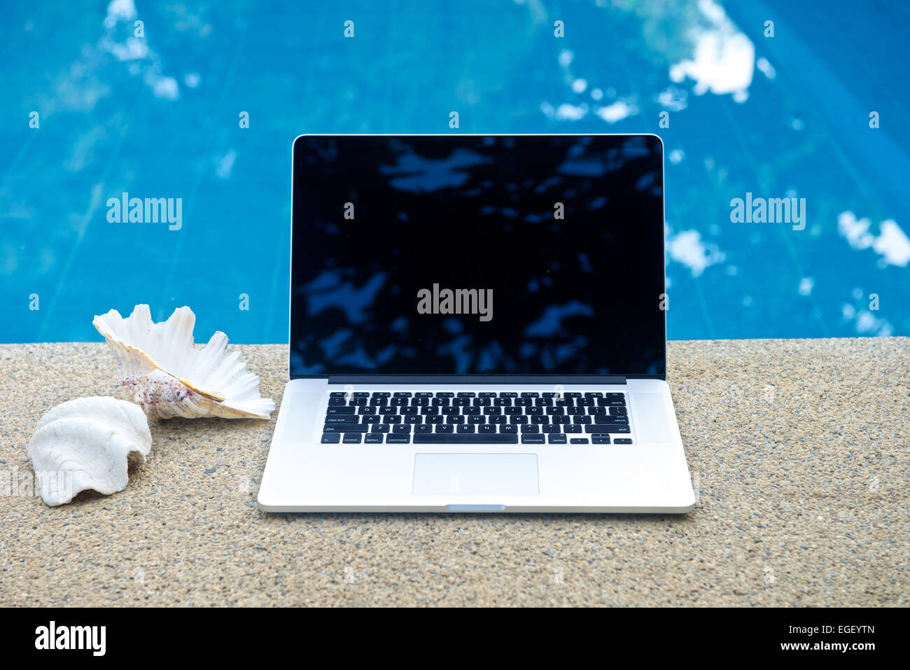 Laptop by the pool, working on vacation with mobility concept Stock Photo