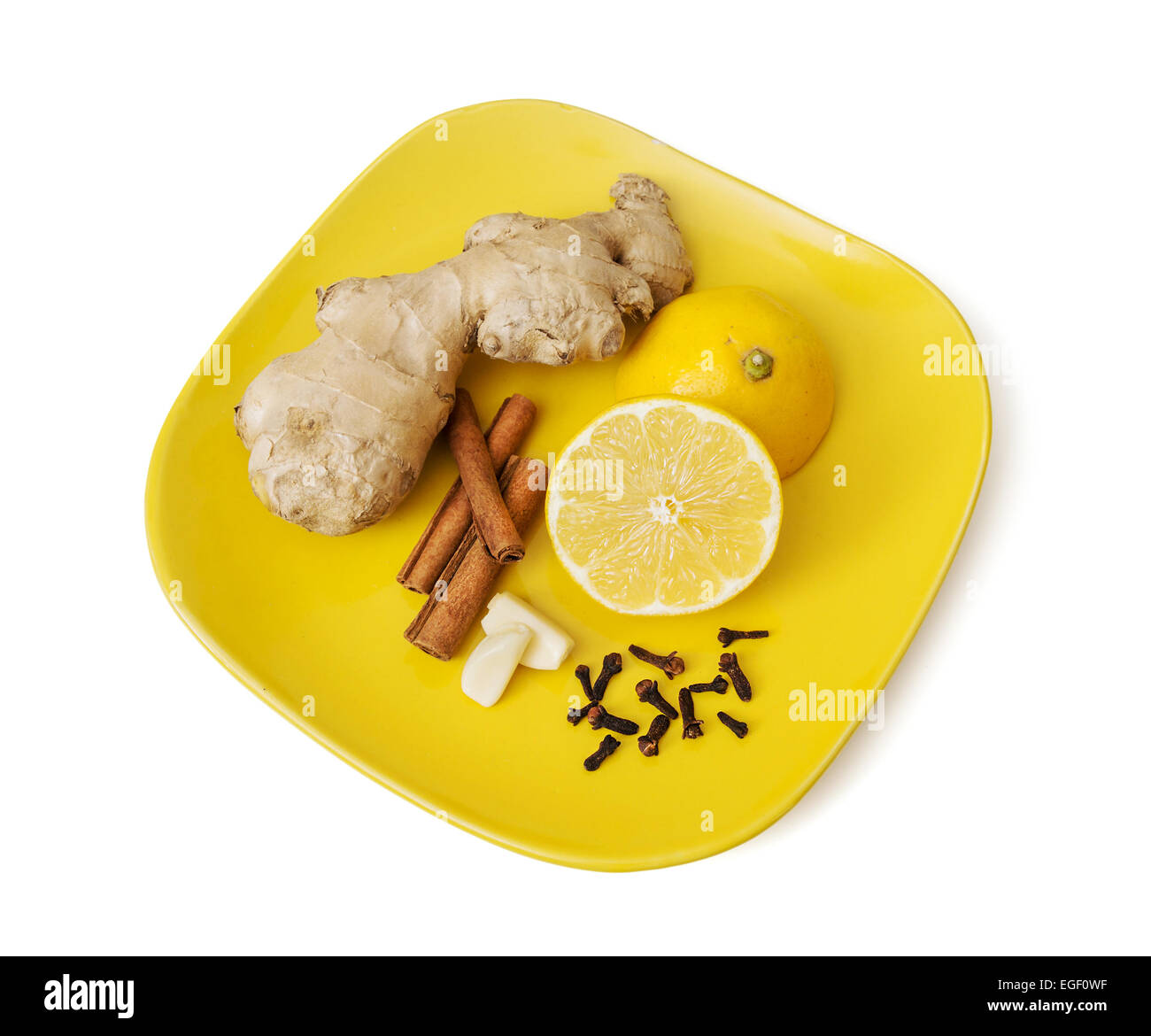 Ginger, cinnamon, lemon, garlic and cloves on the plate. Healthy food