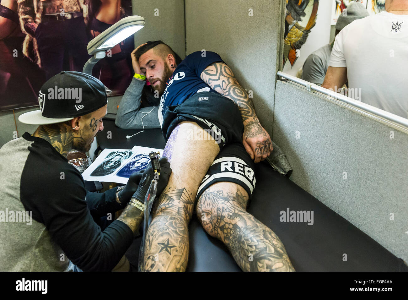 A man being tattooed on his leg at the Brighton tattoo Convention. Stock Photo