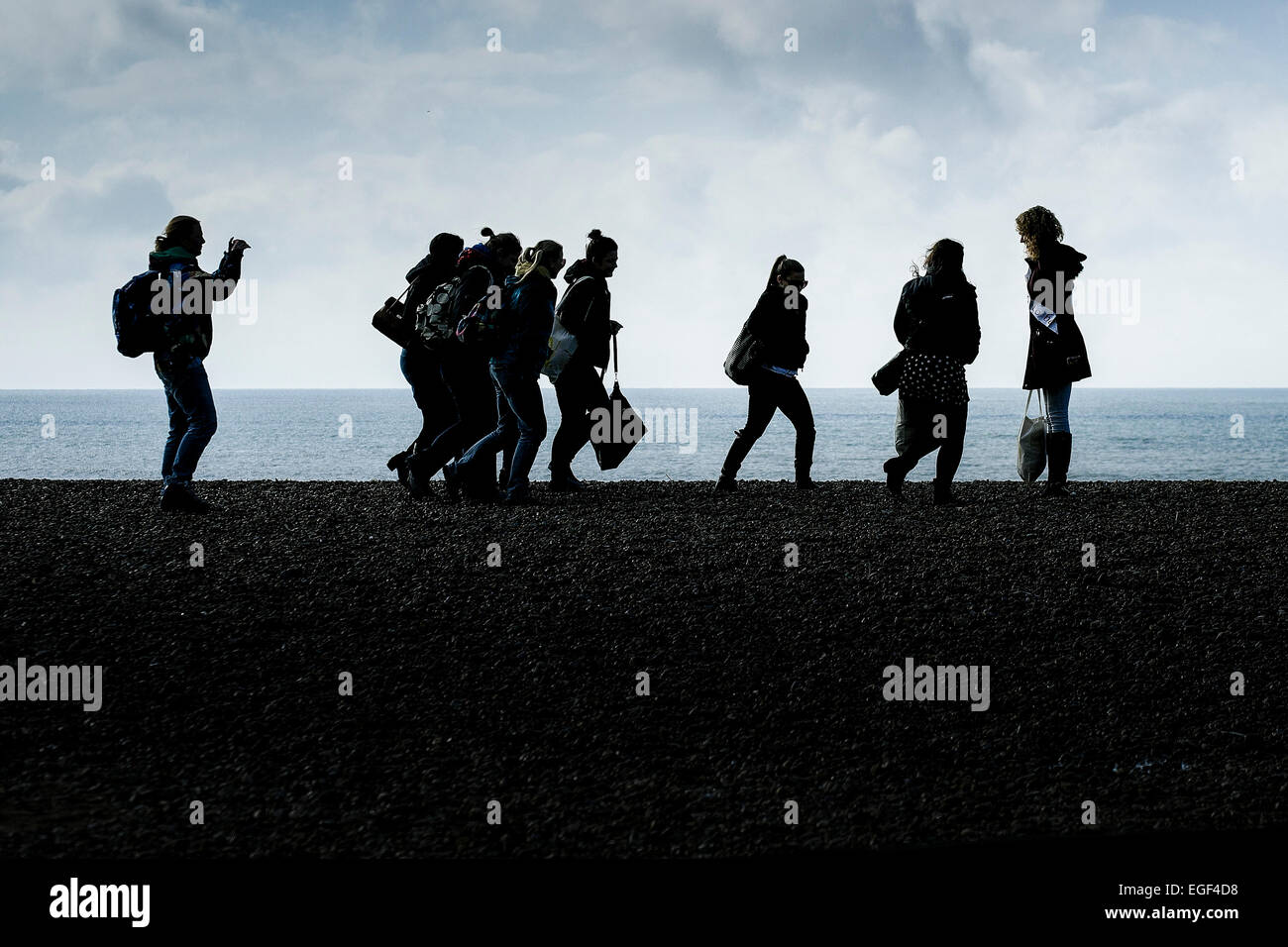 The silhouette of a group of females walking across the beach at Brighton. Stock Photo