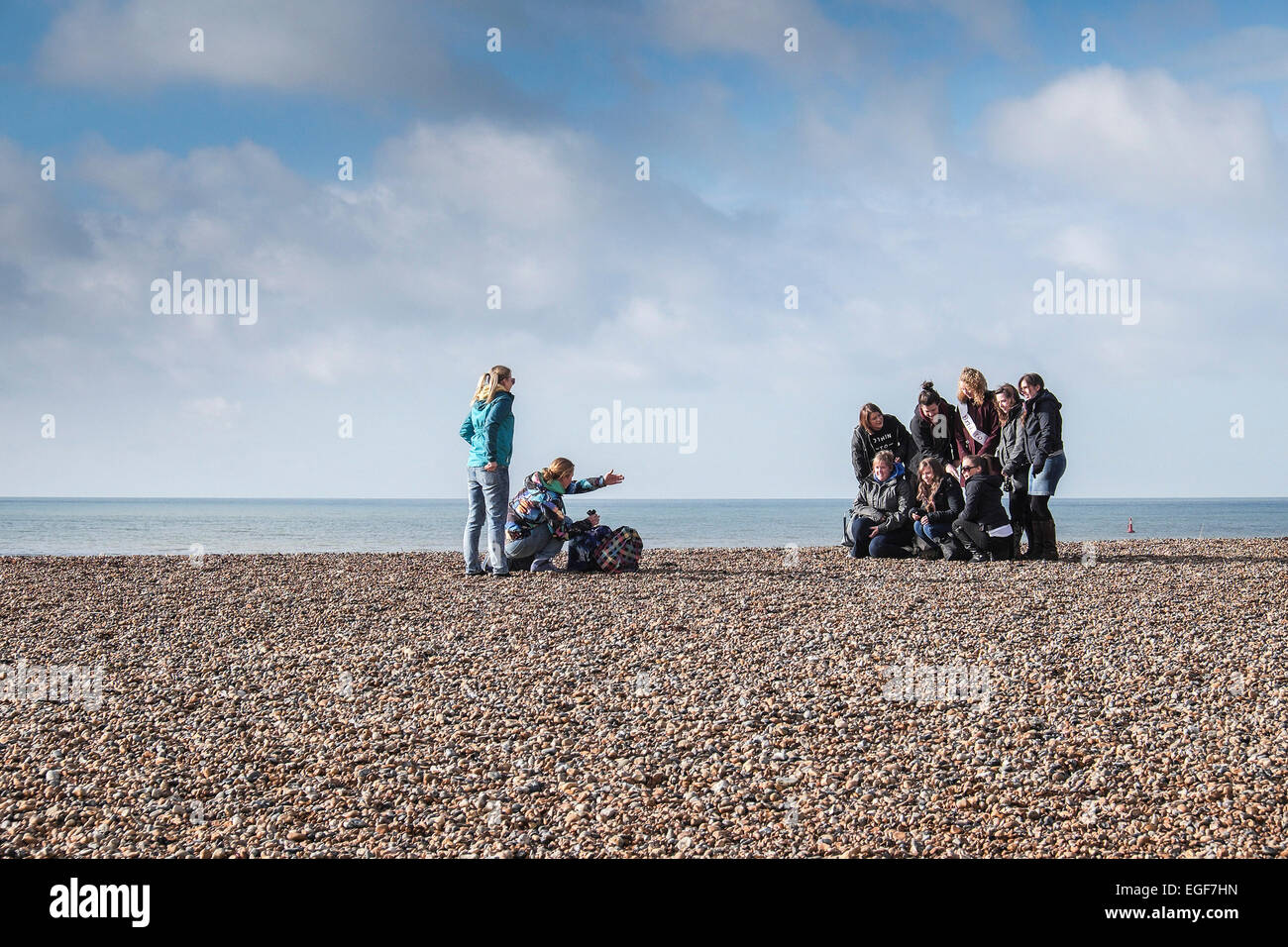A group of friends posing for a photograph on the beach at Brighton ...