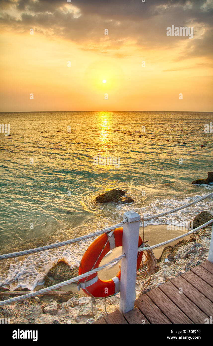 The sun sets over the Caribbean Ocean from the lounge decks of a luxury Resort. Stock Photo