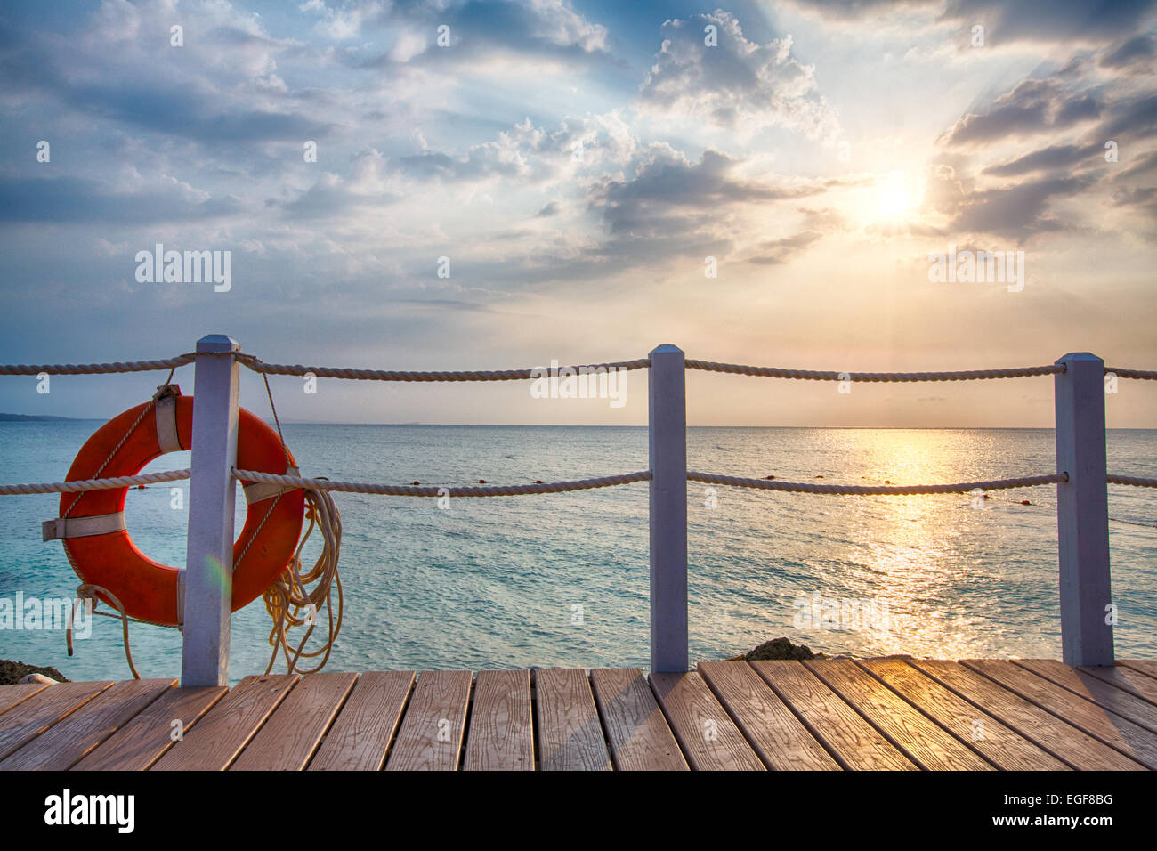 The sun sets over the Caribbean Ocean from the lounge decks of a luxury Resort. Stock Photo