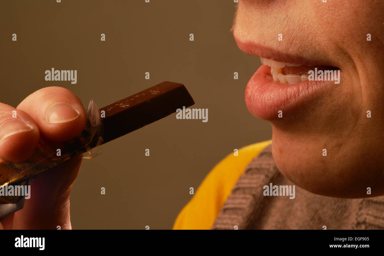 Symbolic picture about sugar in foods: Woman eating chocolate. Stock Photo