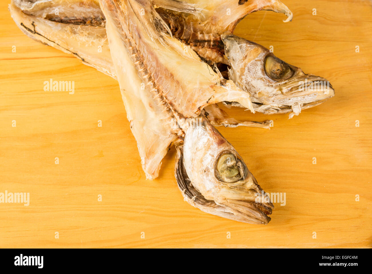 Two dried and salt cured whitings on a chopping board Stock Photo Alamy